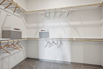 A walk in closet with hangers and a dryer